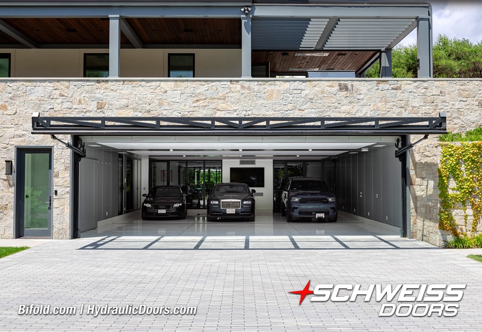View from front of Schweiss custom glass hydraulic door fitted on luxury garage shown open