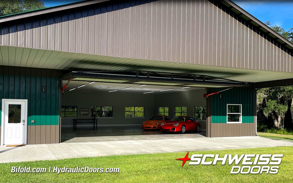 Exterior view from front of Schweiss hydraulic door installed on Moore Car Barn shown open