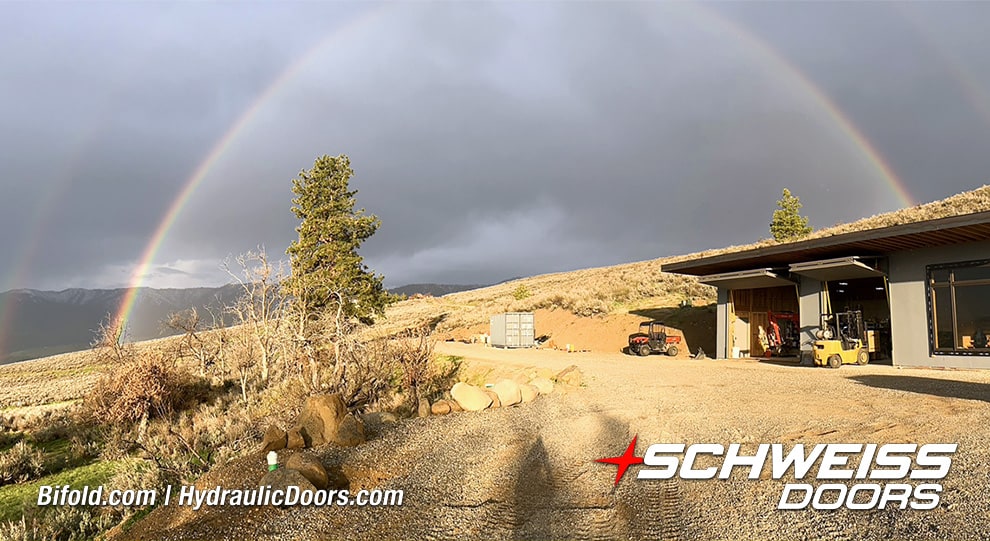 View of a rainbow over Roger Bown's building fitted with two Schweiss bifold doors shown open