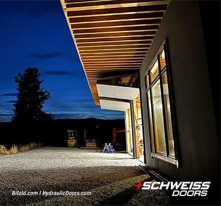 Two opened Schweiss bifold doors fitted on Roger Bown's building shown from the side