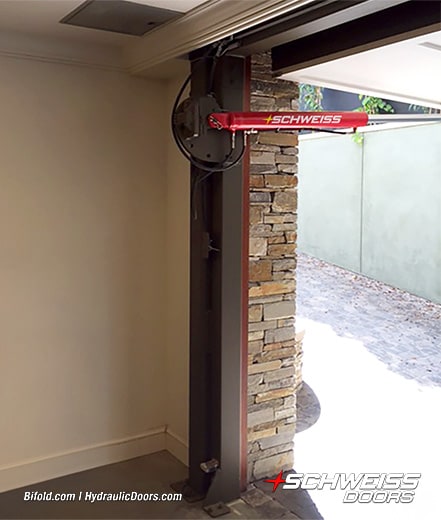 Interior view of hydraulic cylinders used to operate Schweiss hydraulic door fitted on garage