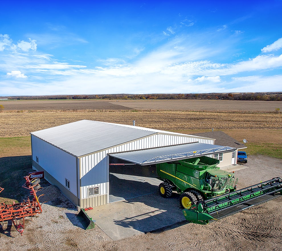 Combine parked underneath Schweiss One Piece Hydraulic Lift Agricultural door