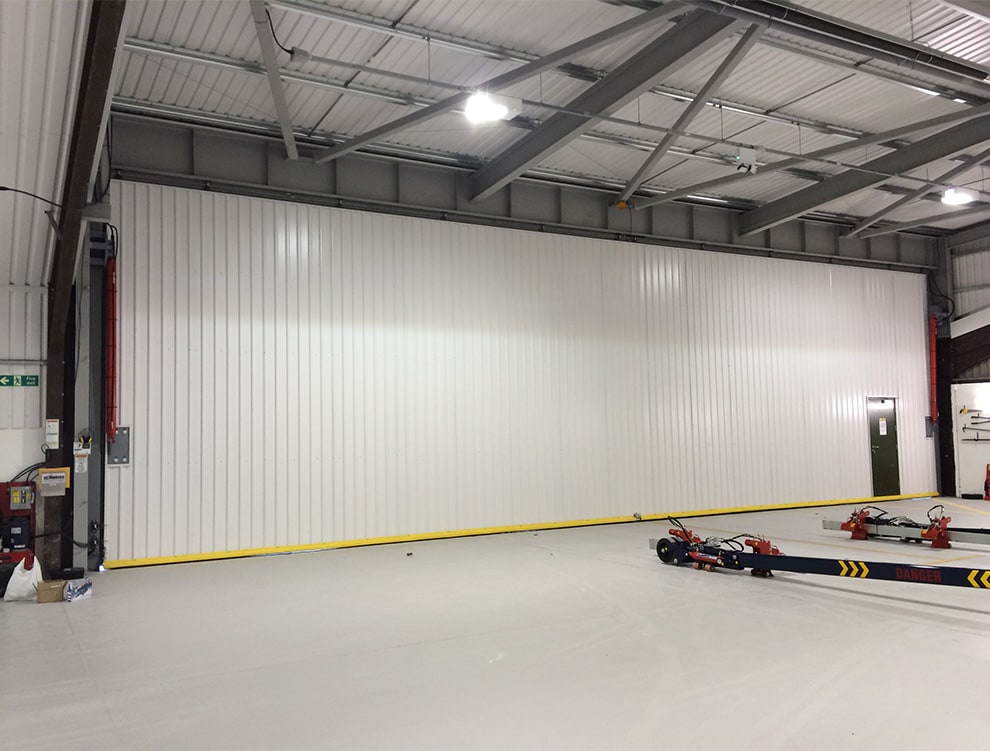 Interior view of a Schweiss hydraulic door fitted with a walkdoor fitted on a building shown closed