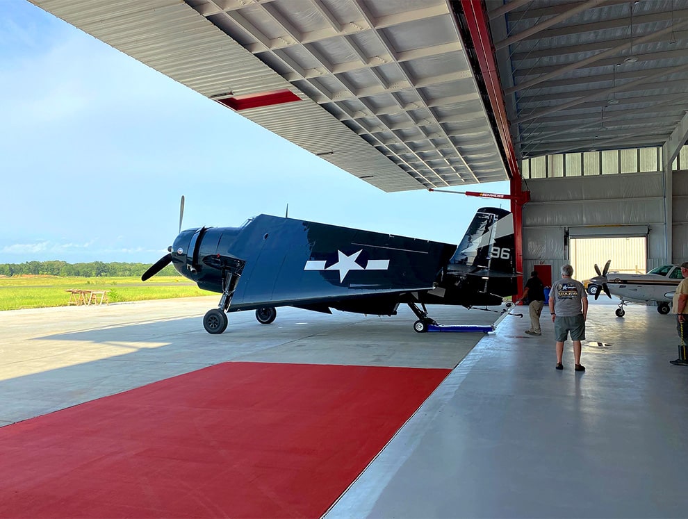 Exterior view of vintage military plane parked underneath an open Schweiss hydraulic door