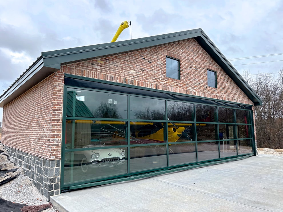 Schweiss hydraulic designer door installed on mancave garage building shown closed