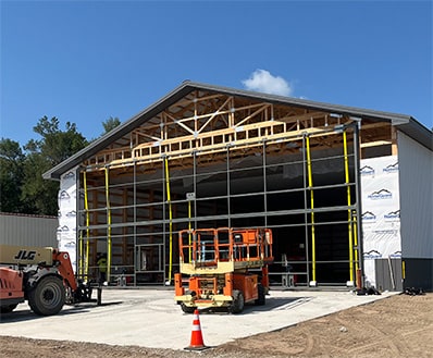 Exterior view of a Schweiss bifold door frame installed on a newly constructed building shown closed