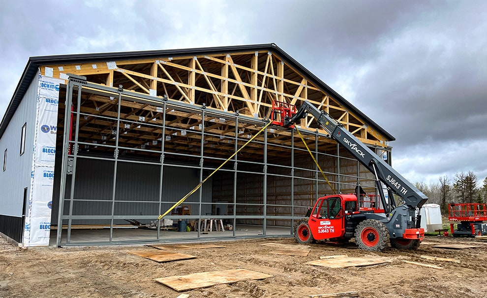 Schweiss hydraulic door being installed onto hangar by Skyjack