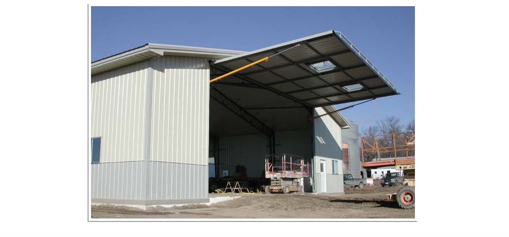 large hydraulic door is installed at farmsite on machine shed