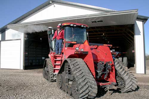 Farmer showing off his equipment storage shed and Schweiss bifold door 