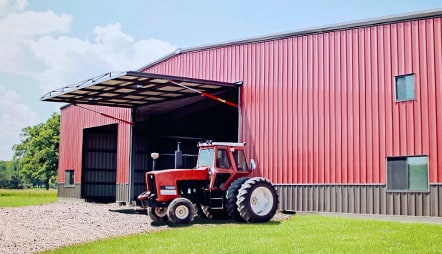 Schweiss hydraulic door installed on building behind parked tractor that could be used for backup power