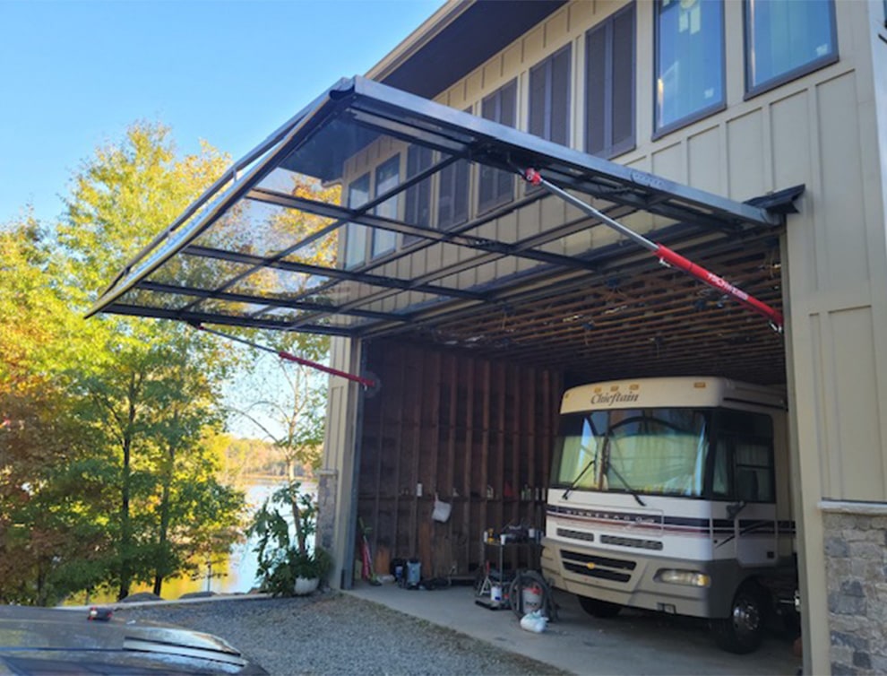 Exterior view of Schweiss hydraulic door made of glass used on RV garage shown open