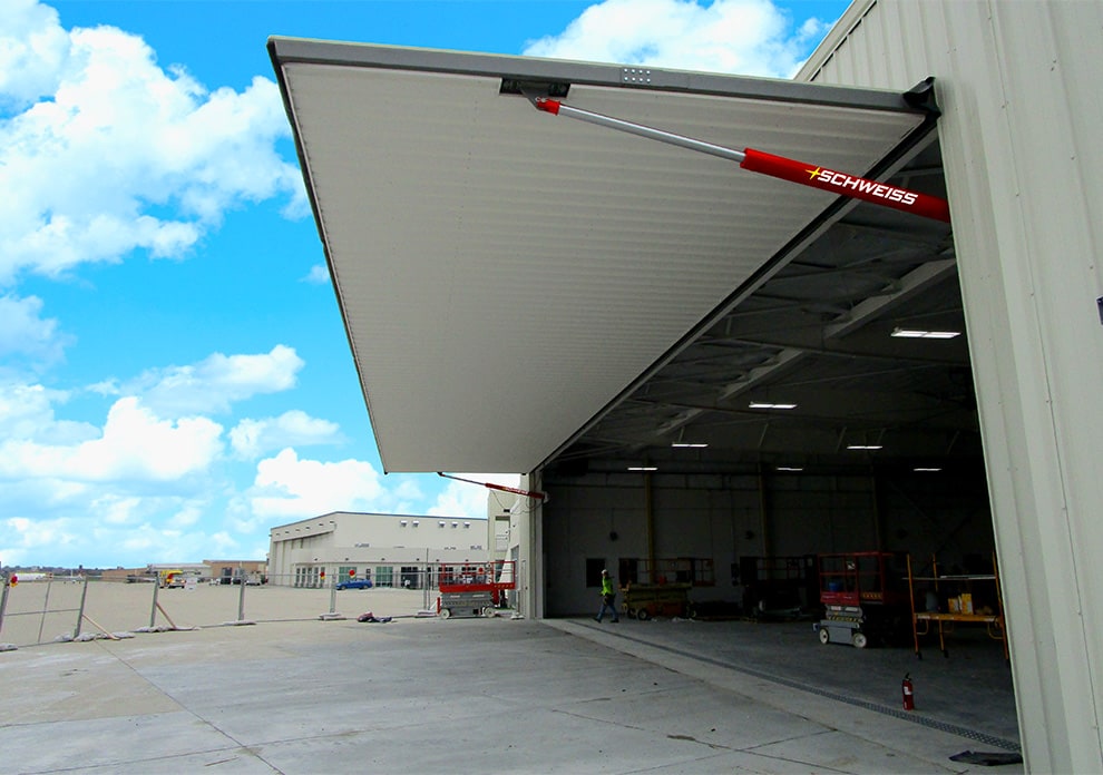 Exterior view from side of Schweis hydraulic door fitted on a hangar shown open