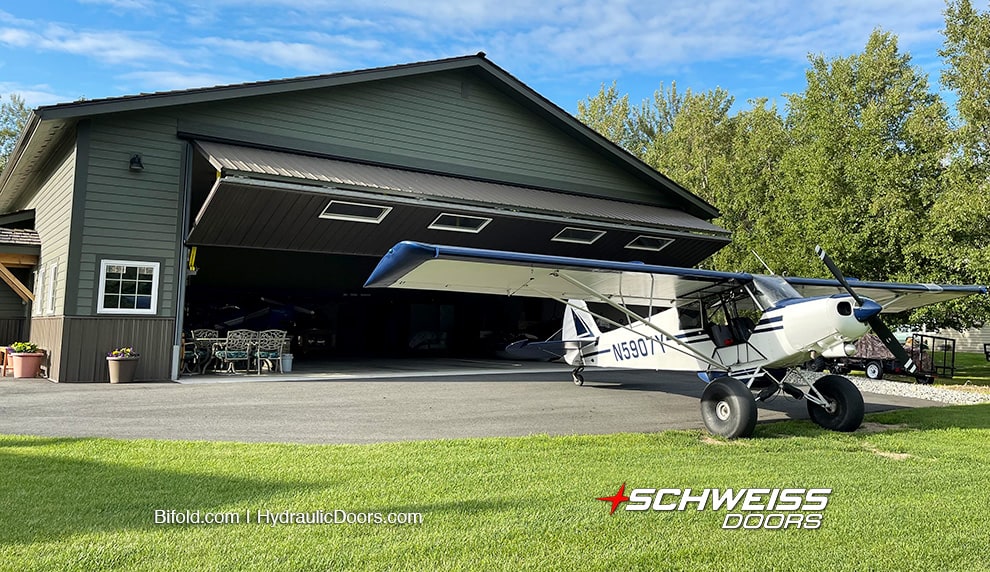 One of the Mueller's planes parked outside their hangar fitted with a Schweiss bifold door