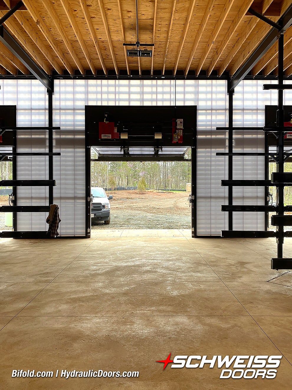 Interior view of 3 of 8 Schweiss bifold doors installed on Beaverdam Reservoir shown open, a truck seen parked outside