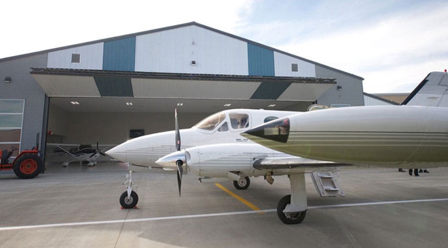 Large aircraft in front of bifold hangar door