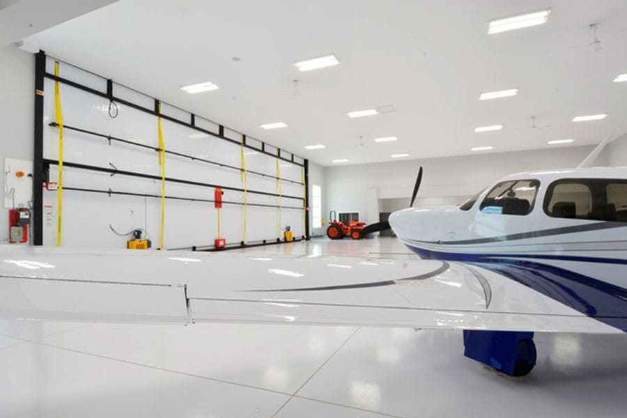 Bifold door hangar with utility tractor