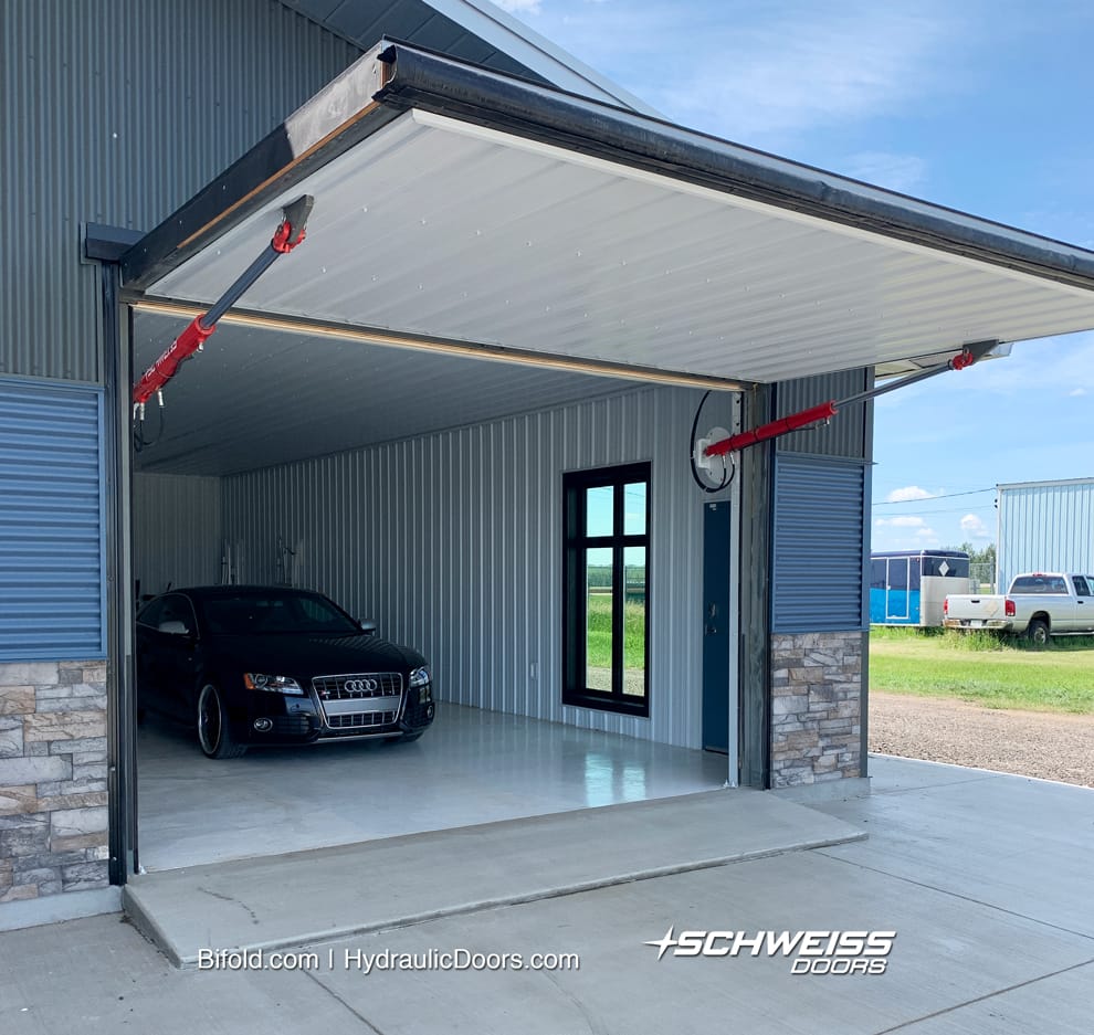 Hydraulic garage door has beveled concrete to keep rain out