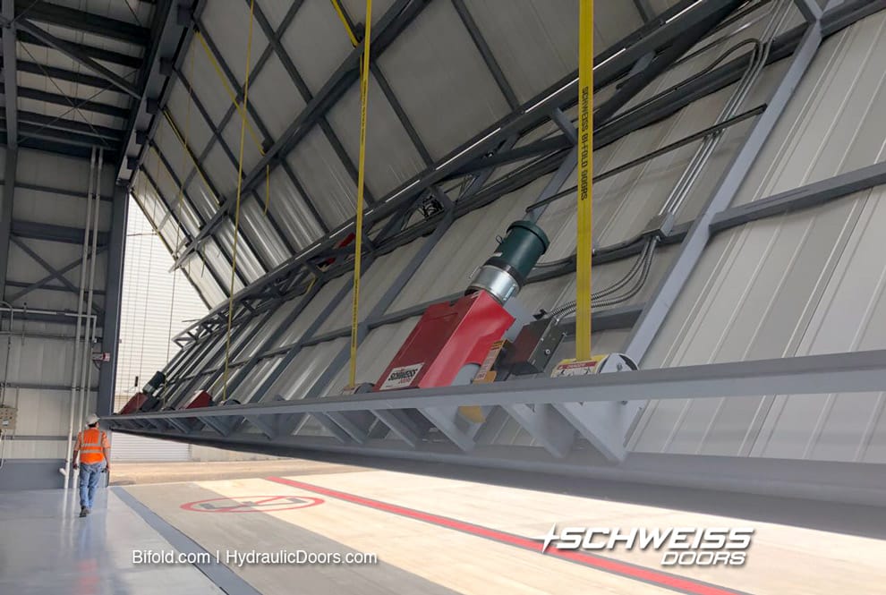 Schweiss Lift Strap Bifold door fitted on hangar in Costa Rica shown opening