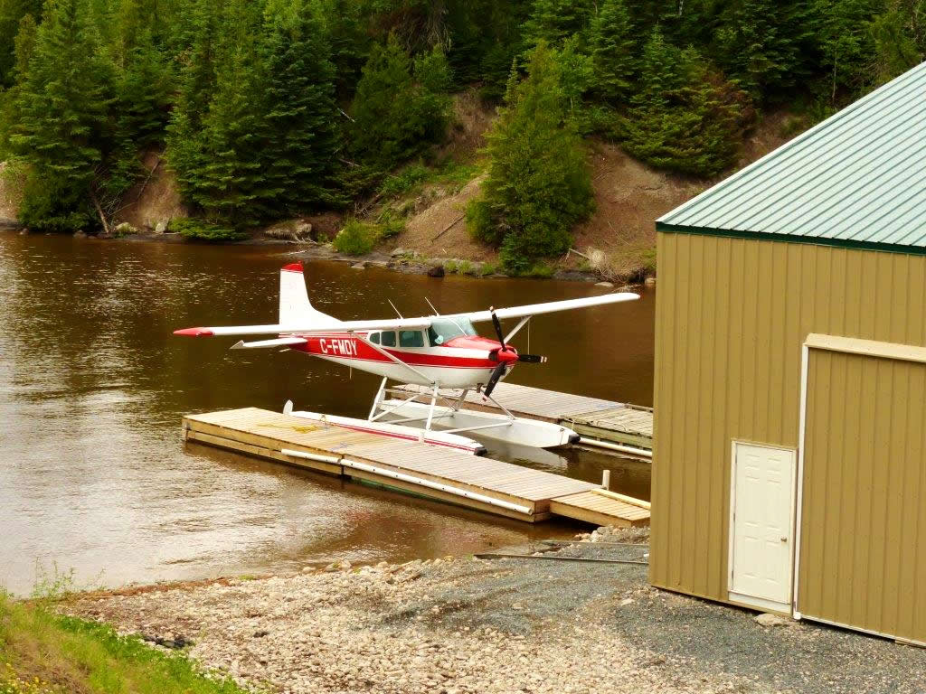 Cessna 185 floatplane sittin in front of the hangar