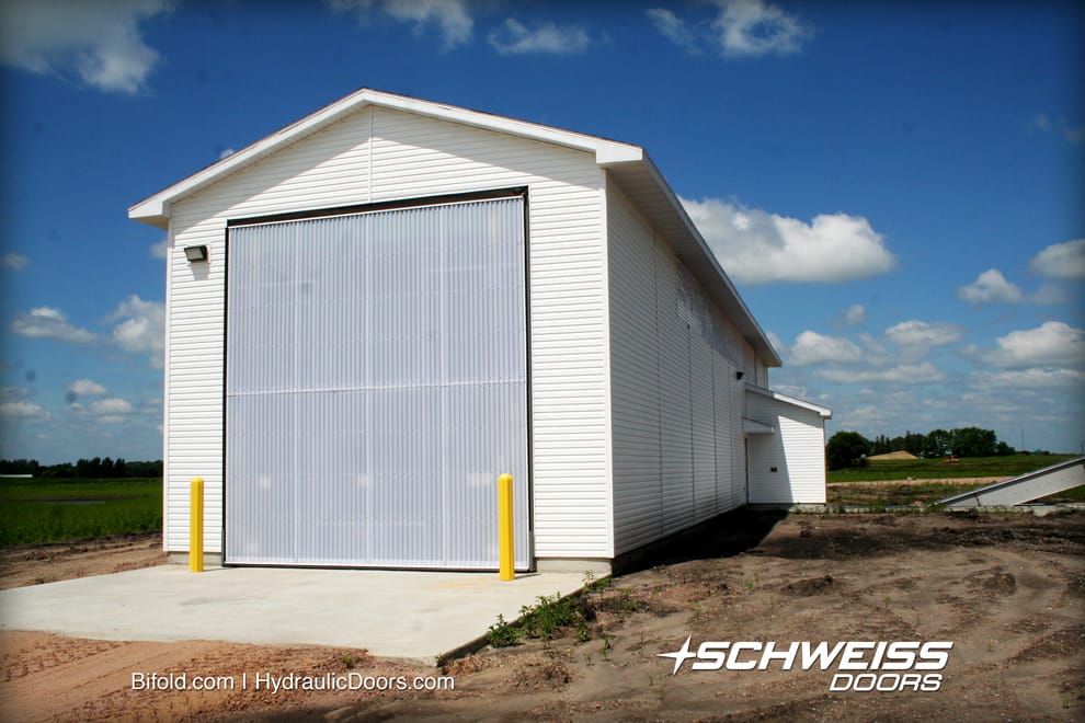 Schweiss Bifold Liftstrap Door is on the exit end of the recieving bay, and CRC purchased dustproof motors, and automatic latch systems