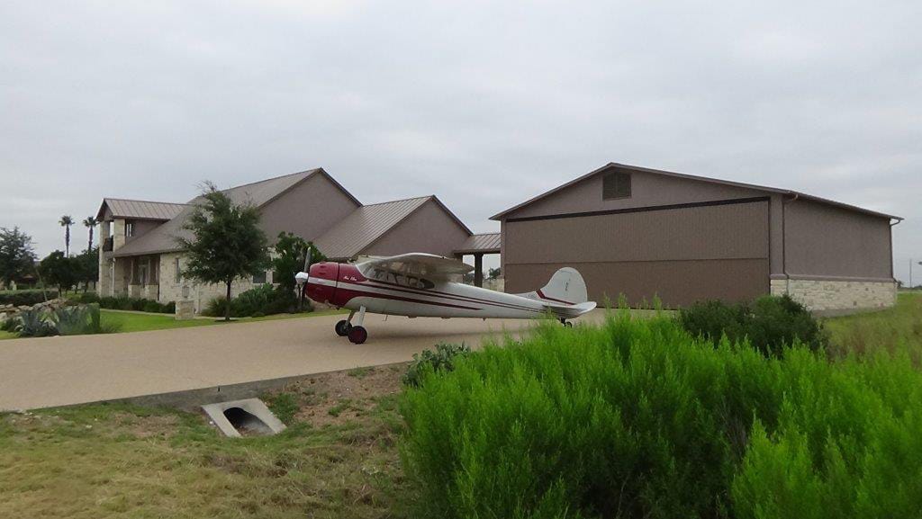 Texas Hangar Home, Horseshoe Bay | Schweiss Must See Photos  The closed bifold door, the hangar, the plane (a Cessna 195).