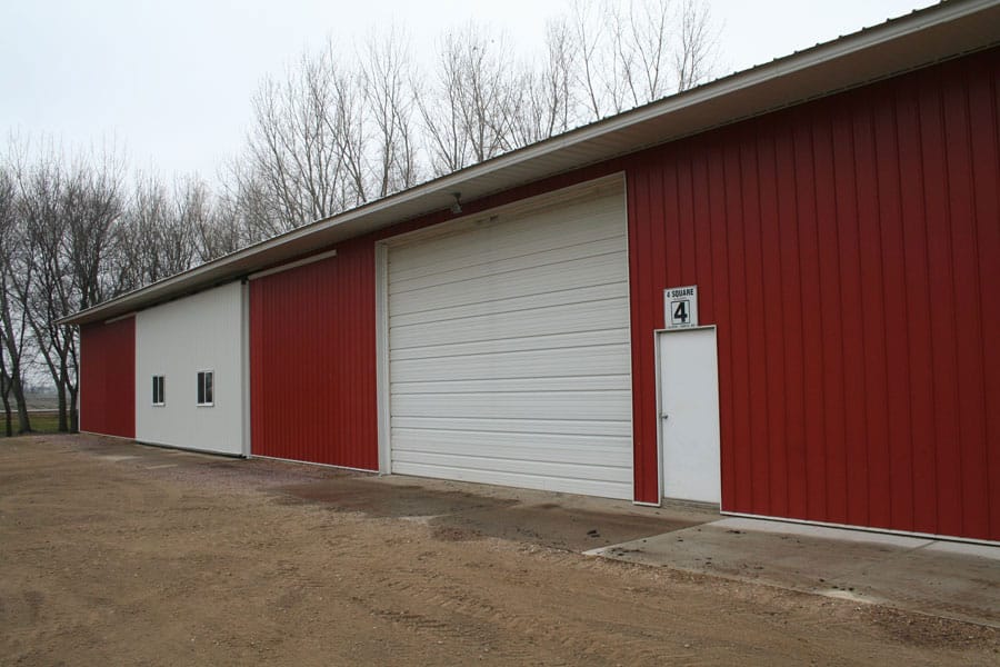 Hydraulic door on end of machine shed maximizes headroom, makes using doors trouble-free.