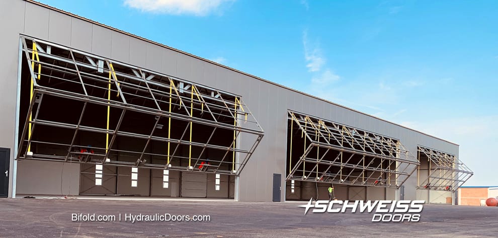 Three liftstrap bifold doors installed on Vienna hangar are lifting up 