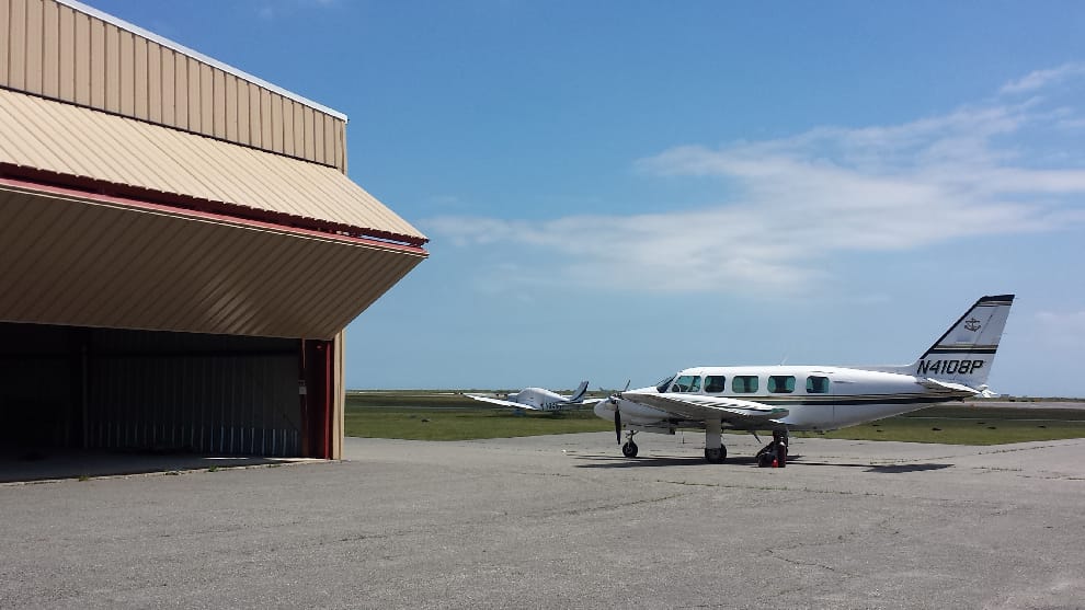 Commuter planes housed in this hangar outfitted with straplift bifold door