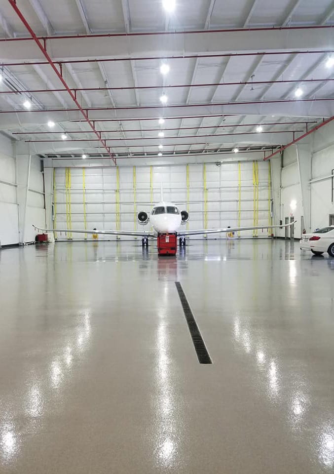 Jet parked inside of another hangar at Southern Wisconsin Regional Airport built by Paulson Kimball Construction fitted with a Schweiss bifold liftstrap door