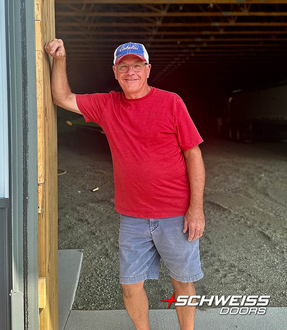 Keith Peterson posed leaning against the frame of his Schweiss door