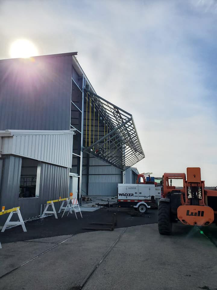 Schweiss bifold door being installed on Cloudkisser hangar built by Paulson Kimball Construction at Southern Wisconsin Regional airport shown opening