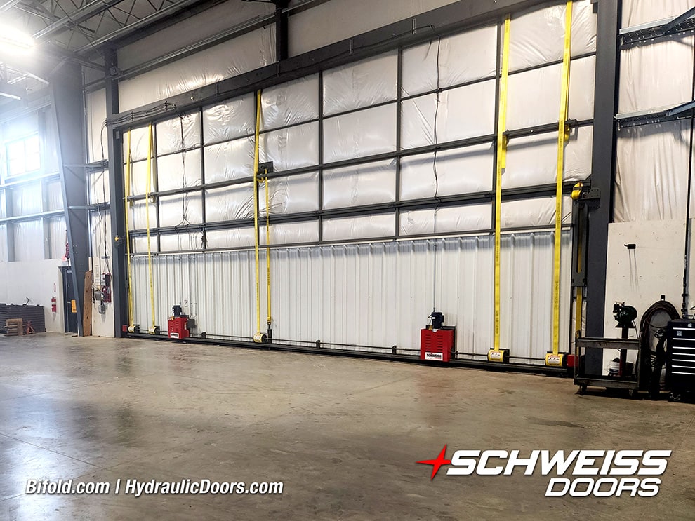 Interior view of Schweiss liftstrap bifold door fitted on Redline Equipment building shown closed Interior view of Schweiss liftstrap bifold door fitted on Redline Equipment building shown closed