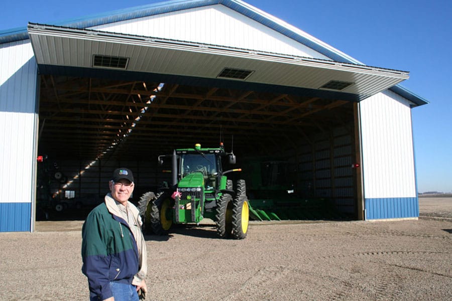 Farmer and tractor in front of machine shed