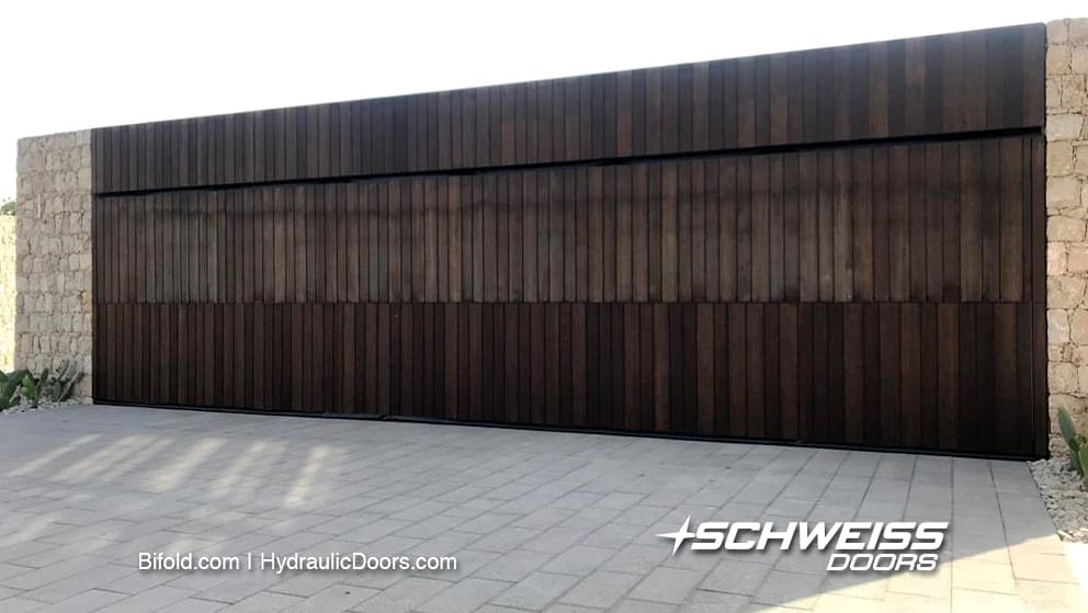 Schweiss wood-clad designer doors are equipped with door base safety edges, automatic latch systems and remote opening systems.