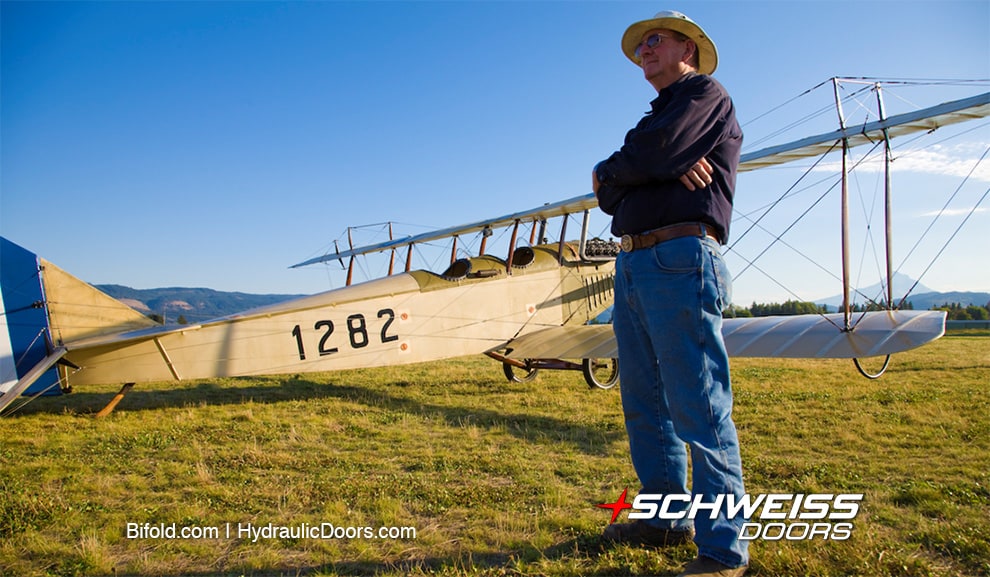 Terry Brandt, founder of WAAAM, standing in front of a 1917 Curtiss JN-4D