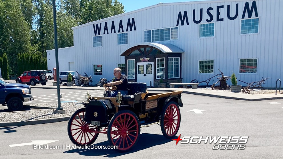 1913 IH Auto Wagon from WAAAM's collection being driven in front of WAAAM's main building