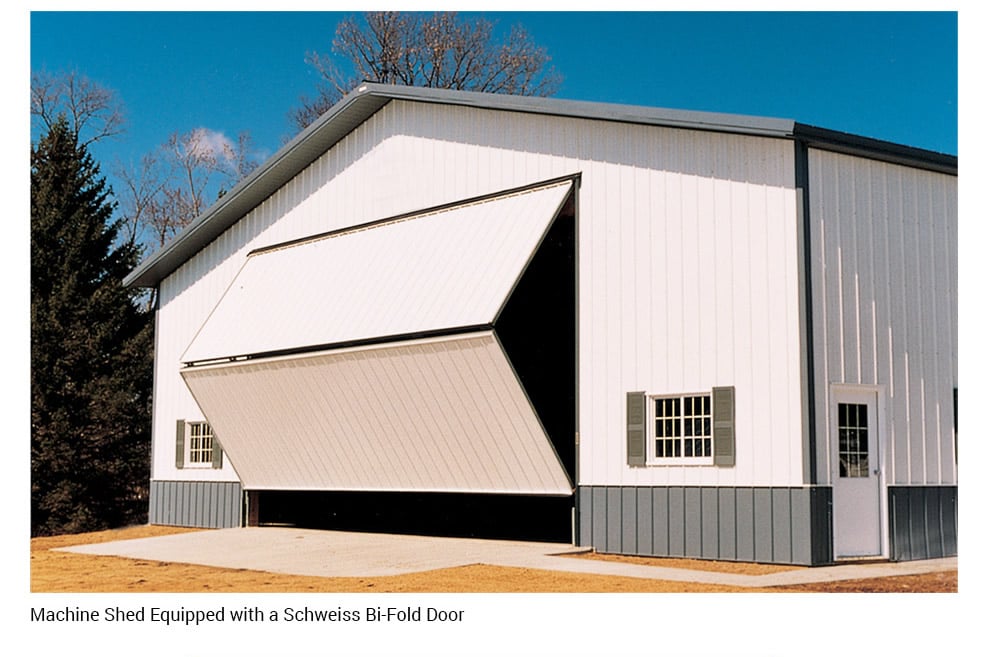 Wide Schweiss bifold doors installed to store large equipment in pole barn