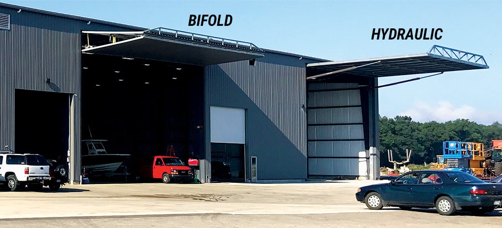 A hydraulic and bifold door side-by-side from Nebraska Doors by Schweiss, both shown open