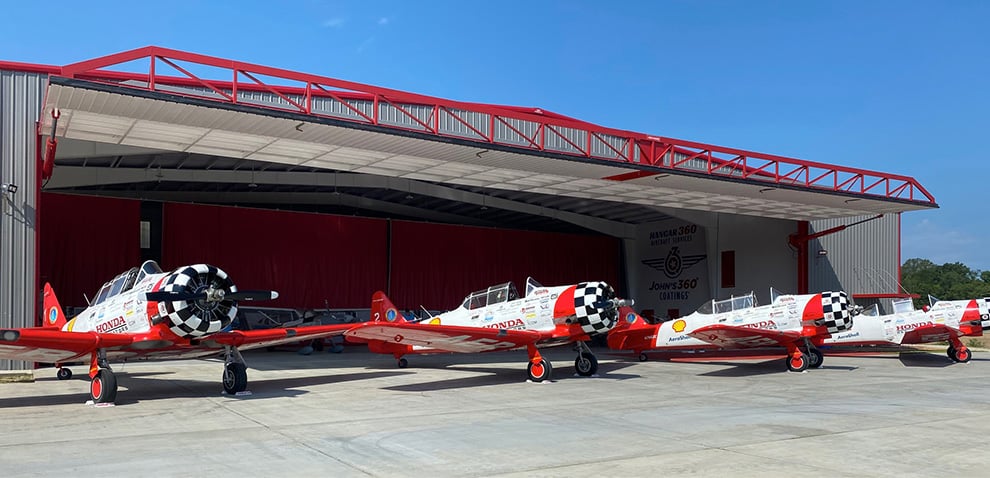 Row of planes outside of hangar fitted with a Schweiss Door