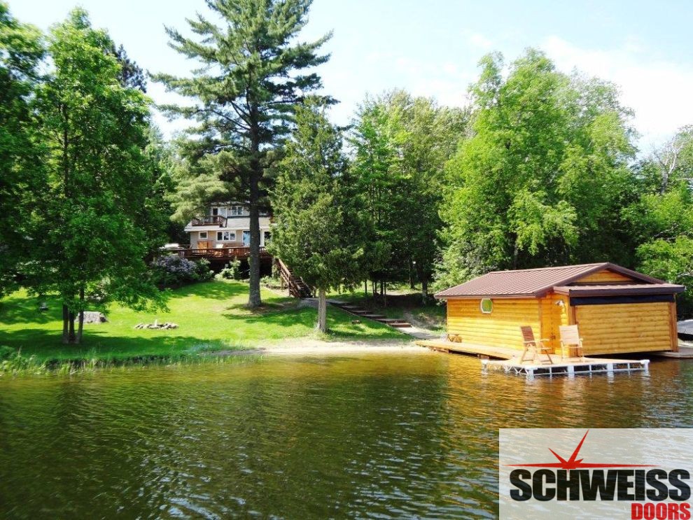 Lake home hydraulic boathouse door