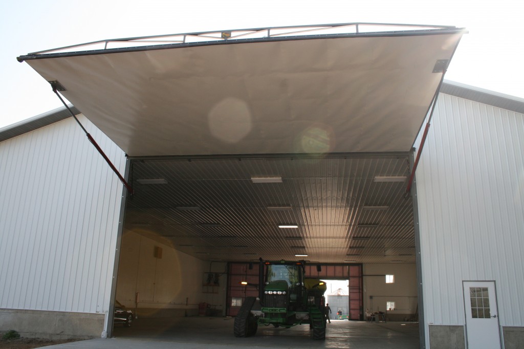 Big hydraulic one piece doors are used by farmers with large tractors and machinery. The Schweiss hydraulic doors have strong cylinders and a compact pump unit.